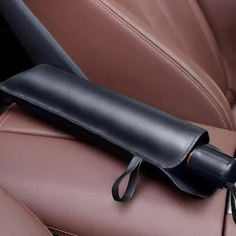 Black umbrella folded and placed inside a car seat
