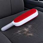 Double-sided pet hair remover brush on a car seat lifting dog hair